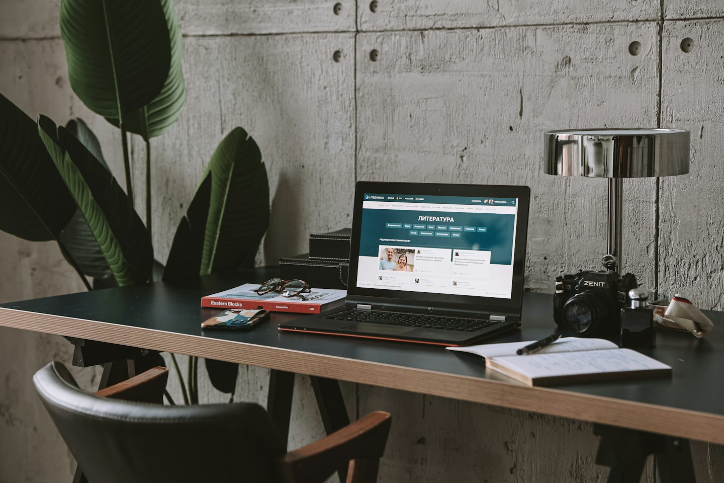 Laptop and office supplies rest on a wooden desk.